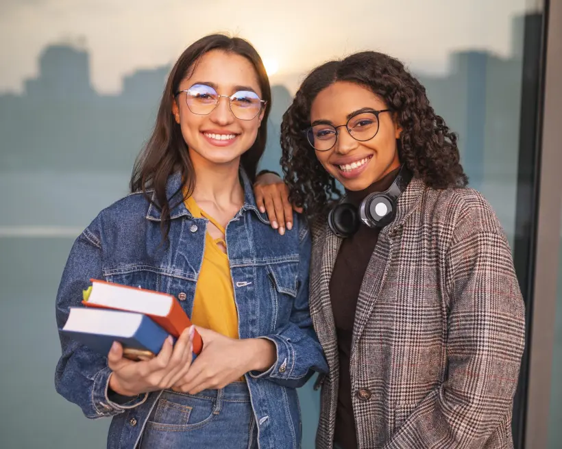 Deux amies complices, livres en main, au coucher du soleil