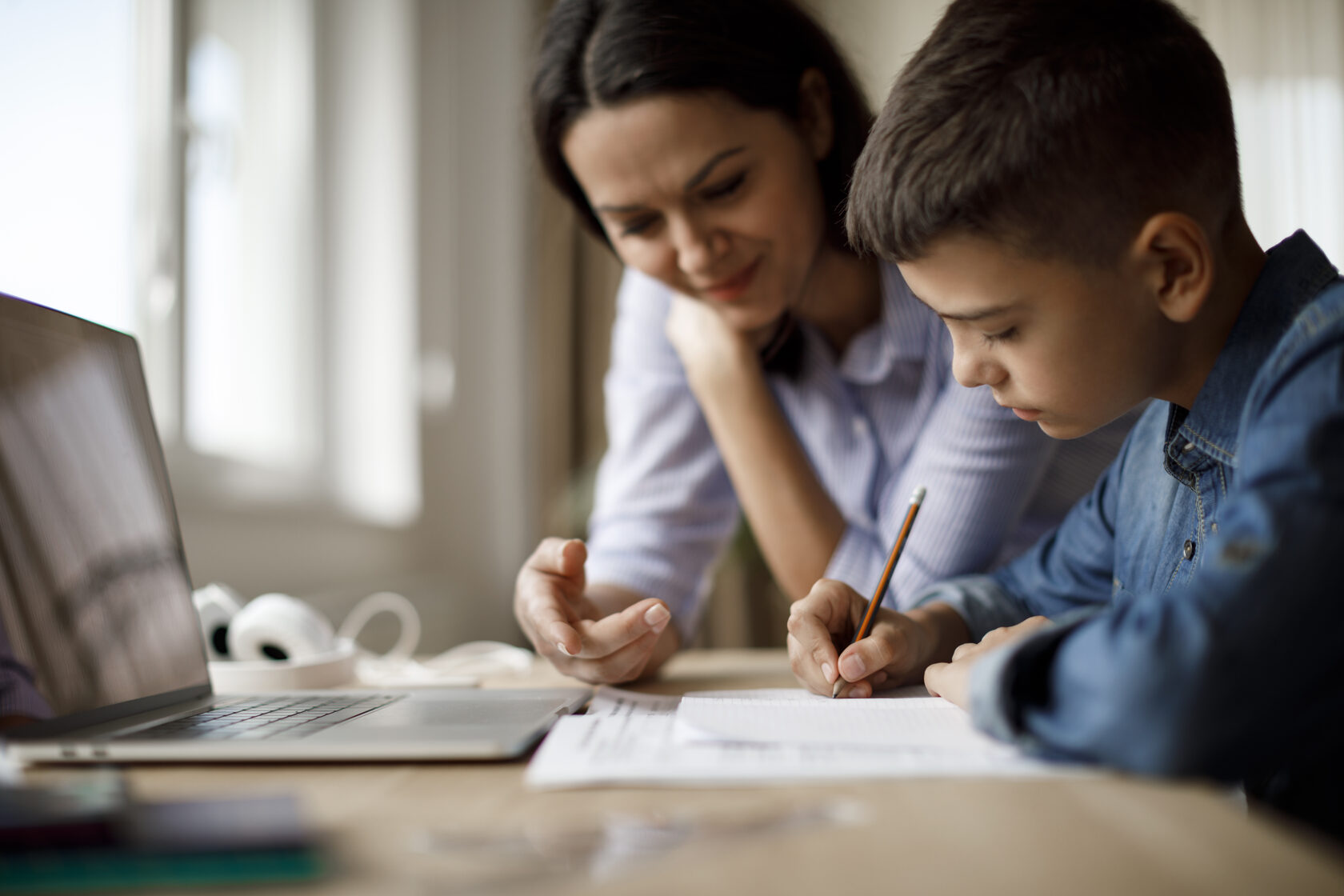 Un enfant qui étudie à la maison avec sa famille